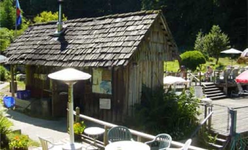 The sauna shed with a tiled roof and a community notice board outside
